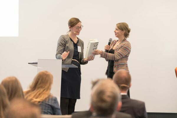 Moderatorin und FAZ-Redakteurin Helene Bubrowski (rechts) überreicht Andrea Stahl  (Gleiss Lutz) ein Präsent.